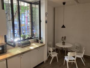 een keuken met een tafel en een tafel met stoelen bij Chillton hostel in Belgrado