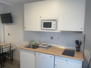 a kitchen with a sink and a microwave at Apartamentos Nueva Berria in Santoña