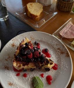 a plate with a piece of cake with berries on it at Entre Rios Lodge in Ranco