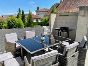a patio with a table and chairs and a grill at Grand appartement proche centre ville et Rocamadour in Gramat