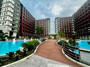 a walkway between two tall buildings with a pool at Dagos condo Primeworld with balcony and pool view in Mactan Island