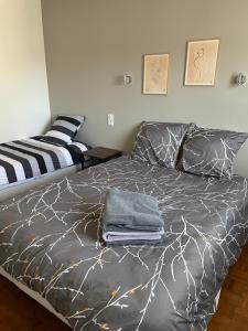 a bedroom with a bed with a gray comforter at Grand appartement proche centre ville et Rocamadour in Gramat