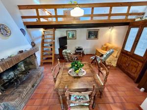 Una sala de estar con una mesa y una chimenea. en La Loggetta dei Poderi - 5' dalle Terme di Saturnia, en Montemerano