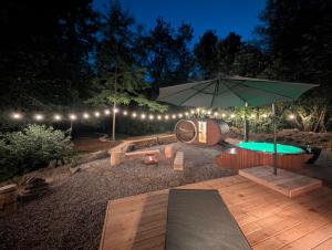 a patio with a table and an umbrella at night at Labe Glamping in Městys Žireč