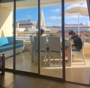 two people sitting at a table on a balcony at Best Sea View in Morocco in Sidi Bouqnadel