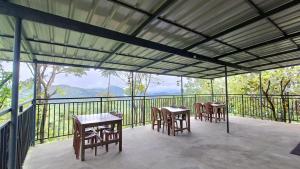 a patio with tables and chairs on a balcony at Mountain Vista Vagamon in Vagamon