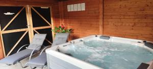 Le Rensy في Ferrières: حوض استحمام ساخن في غرفة بها كرسيين +50 صورة