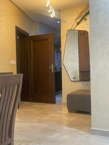 Cette chambre comprend une porte et un miroir mural. dans l'établissement 2CH & 2 SDB à coté de la gare TGV-climatiseur & fibre optique, à Tanger