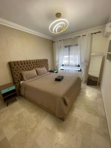 une chambre avec un grand lit et une fenêtre dans l'établissement 2CH & 2 SDB à coté de la gare TGV-climatiseur & fibre optique, à Tanger