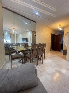 une salle à manger avec une table, des chaises et un canapé dans l'établissement 2CH & 2 SDB à coté de la gare TGV-climatiseur & fibre optique, à Tanger