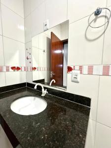 ein Badezimmer mit Waschbecken und Spiegel in der Unterkunft Davisis - Casa Ampla 2 Quartos e Garagem grande in Palmas + 23 Fotos