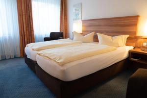 a bedroom with a large bed in a hotel room at Hotel Jägerhof in Bad Hersfeld