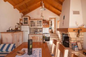 a kitchen with a wooden table and a fireplace at Holiday Home Queen of Kornati in Vrulje