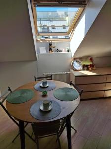 une salle à manger avec une table en bois et quatre chaises dans l'établissement Cozy Studio in Vilnius Old Town, à Vilnius 4 autres photos