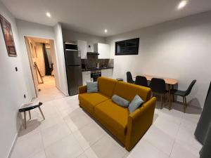 un soggiorno con un divano giallo e un tavolo di Par koté l'ombraz' a Saint-Paul
