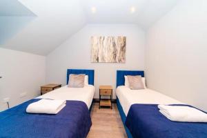 Dos camas en una habitación con azul y blanco. en Stylish 2BR Central Near Pier, en Brighton & Hove