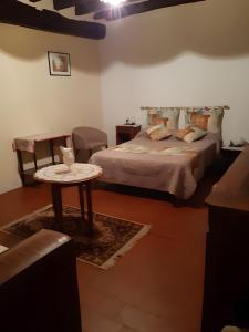 una camera da letto con un letto, un tavolo e una sedia di Gîte 35 a Couffy
