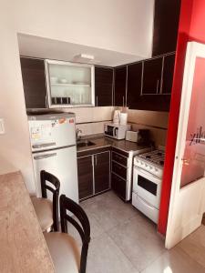 a kitchen with black cabinets and a white refrigerator at Colorado in Mendoza