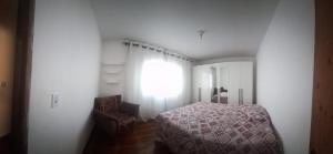 a bedroom with a bed and a window at Casa da Marlene in Resende