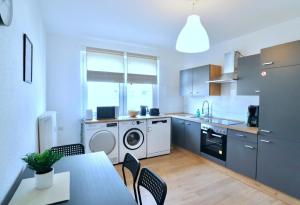 a kitchen with a washing machine and a table and chairs at Work Inn Rhein Ruhr Appartement in Duisburg