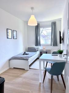 a bedroom with a bed and a table in it at Work Inn Rhein Ruhr Appartement in Duisburg +23 photos