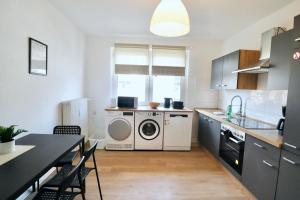 a kitchen with a washer and dryer in it at Work Inn Rhein Ruhr Appartement in Duisburg