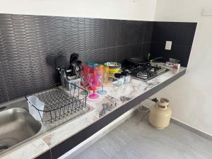 a kitchen counter with a sink and a stove at Lindo depto 2 piso cerca de la playa in Chabihau