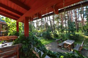 a patio with a table and chairs in a garden at Pas Edgarą 2 in Nida