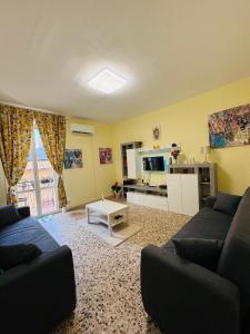 a living room with a couch and a kitchen at Profumo di Sicilia Augusta in Augusta