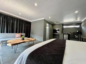 a bedroom with a large bed and a couch at OR Tambo Guest Retreat Unit 4 in Boksburg
