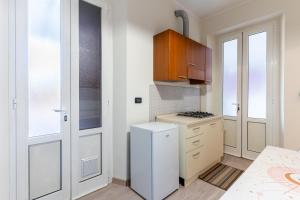 a kitchen with a stove and a white refrigerator at Zen Retreat per Coppie con Jacuzzi - Dehor e Garage Privato - Check in Automatico 24 7 in Casale Monferrato +15 photos