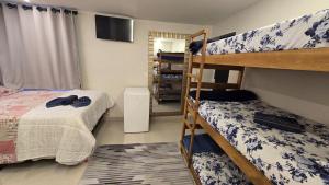 Un dormitorio con dos literas y un televisor. en CASA HOTEL PIRACICABA, en Piracicaba 153 fotos más
