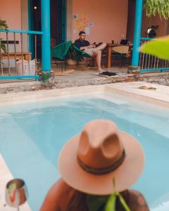 a person wearing a cowboy hat sitting in a swimming pool at Casa la batuta in Santa Fe de Antioquia +14 photos