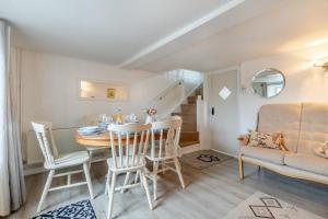 uma sala de estar com uma mesa, cadeiras e um sofá em Shamrock Cottage em Hindringham