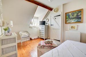 1 dormitorio con cama, silla y vestidor en Old Beams, en Stiffkey