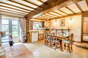 une cuisine et une salle à manger avec une table et des chaises dans l'établissement Orchard Cottage, à East Dereham