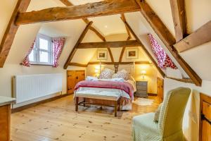 une chambre avec un lit dans un grenier dans l'établissement Orchard Cottage, à East Dereham