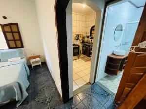 a room with a bed and a bathroom with a sink at Casa na Vila do Abraão - Ilha Grande in Angra dos Reis +30 photos