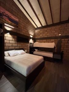 a room with two beds and a brick wall at HOTEL & RV PARK ROSA EVELYN in San Quintín