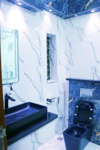 a bathroom with a sink and a toilet at See2ru Burj Apartment and Lounge in Abuja