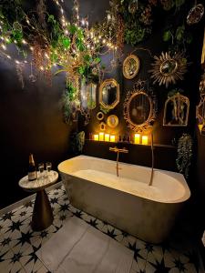 a bath tub in a bathroom with lights and mirrors at Suite Romantique, hyper centre in Caen