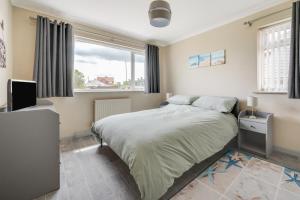 Un dormitorio con una cama grande y una ventana. en LAmourette, en Bacton