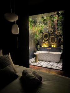 a bedroom with a bathroom with a tub and a sink at Suite Romantique, hyper centre in Caen
