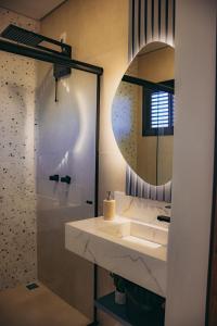 a bathroom with a sink and a mirror at Austral Suítes à Beira-Mar in Imbituba