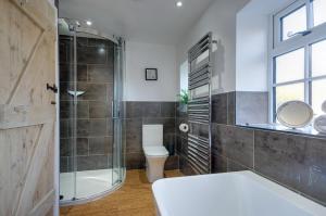 ein Badezimmer mit Toilette und Glasdusche in der Unterkunft Town Yard Cottage in Cley next the Sea