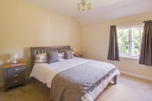 a bedroom with a large bed and a window at Barn Meadow Cottage in Yoxford