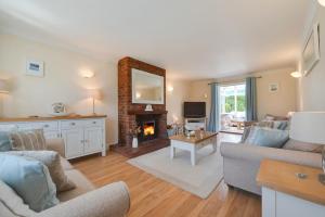 a living room with a couch and a fireplace at Church Meadow Cottage in Trimingham