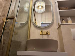 a bathroom with a chair and a mirror at Belvedere Studio Apartman in Vukovar