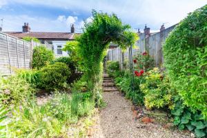 a garden with an ivy covered fence at Poppy Cottage in Briston