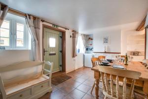 a kitchen and dining room with a table and chairs at Poppy Cottage in Briston